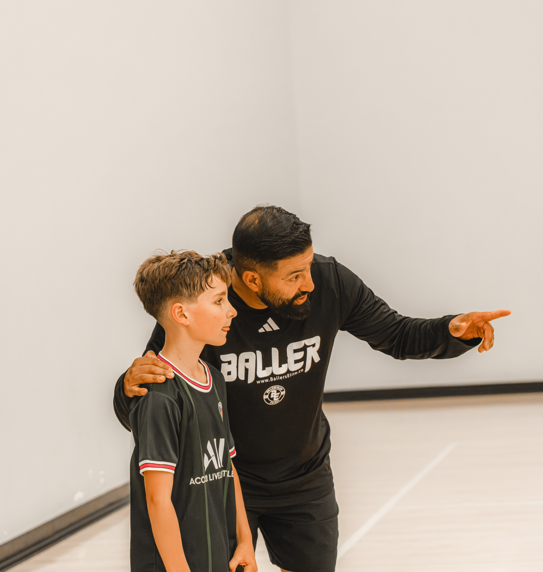 Coach guiding a young player on the futsal court